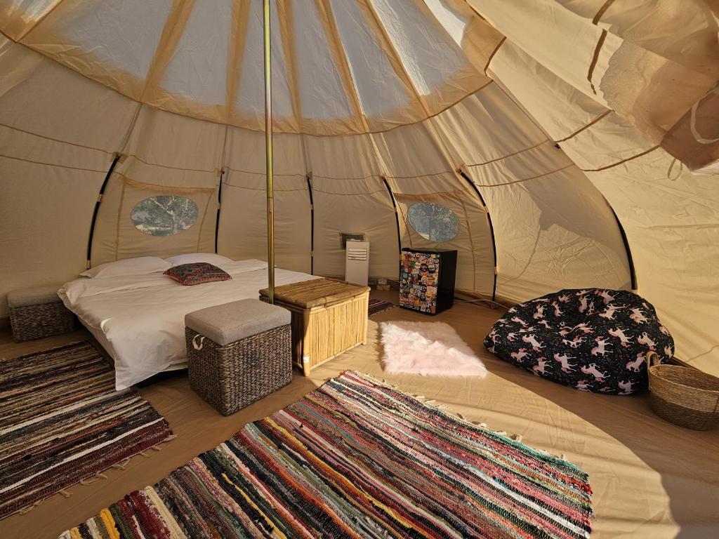 a room with a bed and some rugs in a tent at Ofidaki Glamping in Vama Veche