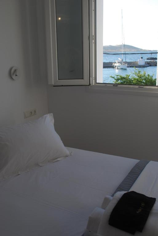 a bed with a window with a view of a boat at Busho Residence 1 in Naousa