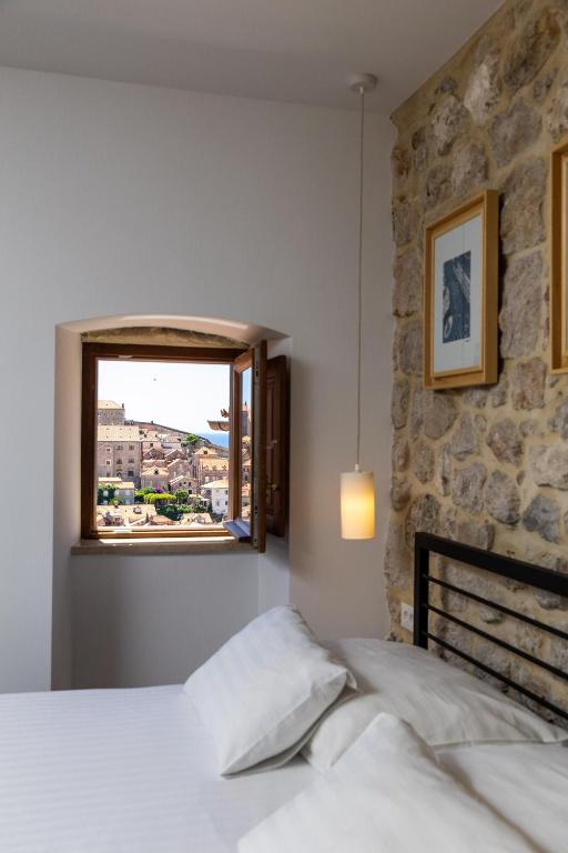 un dormitorio con una cama y una ventana en Villa Four Winds, en Dubrovnik