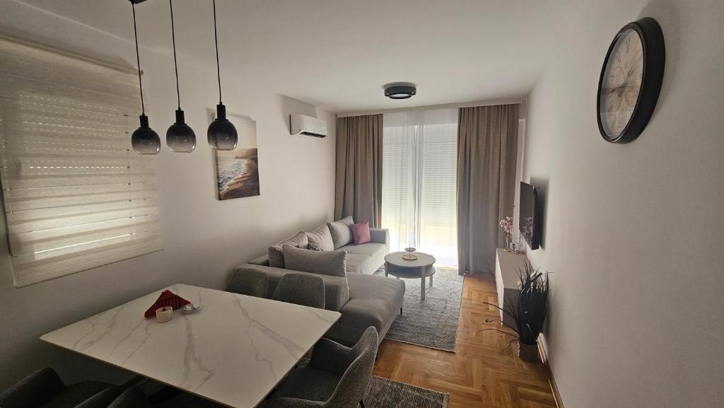 a living room with a couch and a table at Apartman E&A in Radanovići