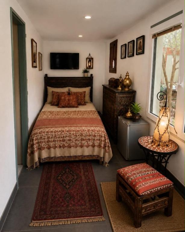 ein Schlafzimmer mit einem Bett und einem Fernseher an der Wand in der Unterkunft Marakesh in Štúrovo