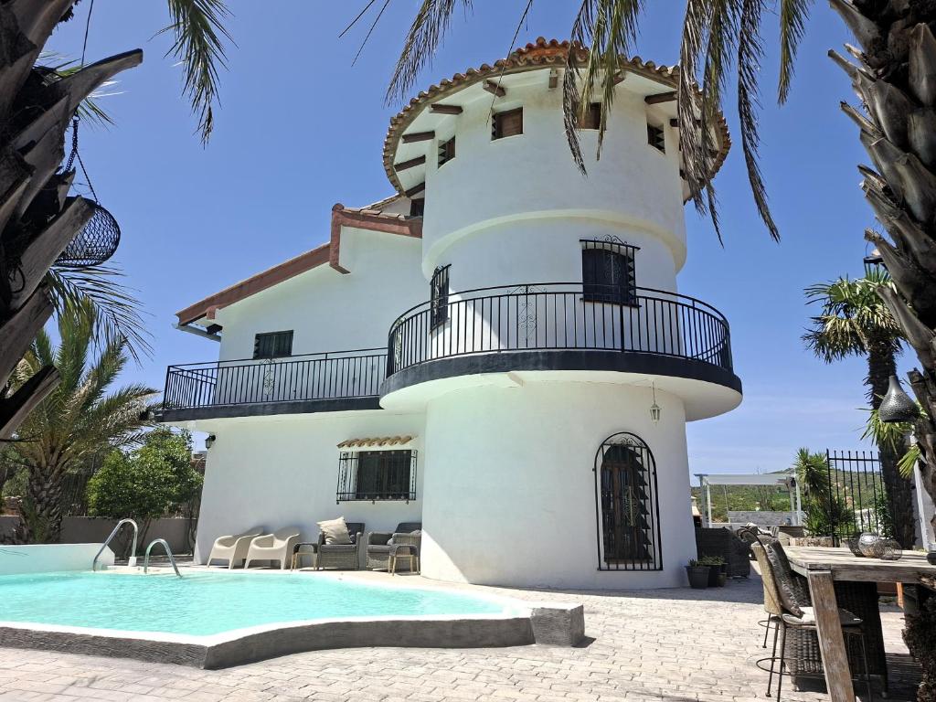 a building with a swimming pool and a lighthouse at Villa Torre Macastre, Valencia in Macastre