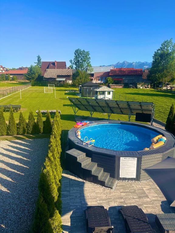 a swimming pool in a yard with chairs and trees at Twoje Miejsce in Czarna Góra