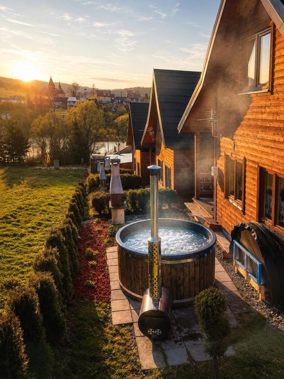 a hot tub in a yard next to a house at Osada Zawóz domki z balią jacuzzi i sauną nad Jeziorem Solińskim in Zawóz