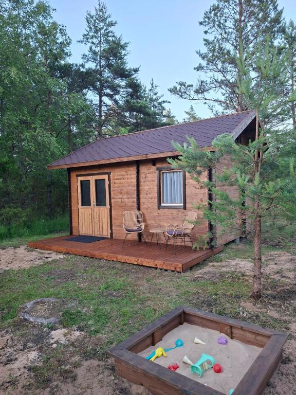 a log cabin with a sandbox in the yard at Puhkemökk in Sõmera