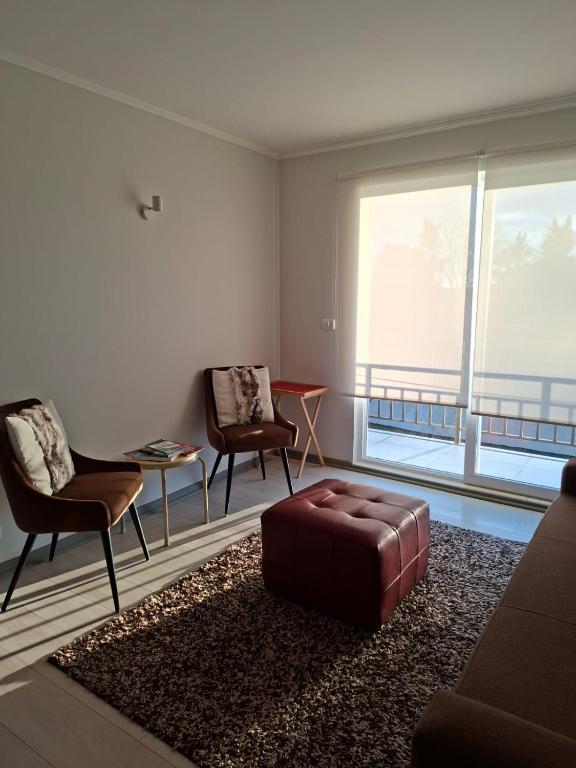 a living room with two chairs and a ottoman at Pucón Soñado Te Espera in Pucón