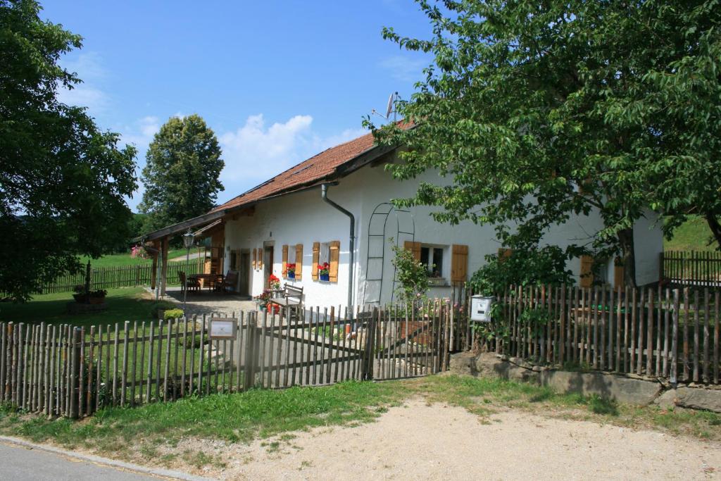 ein weißes Haus mit einem Zaun davor in der Unterkunft Ferienhaus Winter in Blaibach