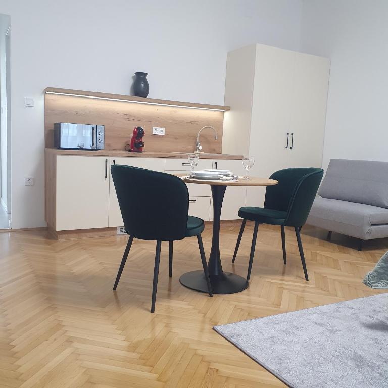 a kitchen with a table and chairs in a room at Bzs5 in Pécs