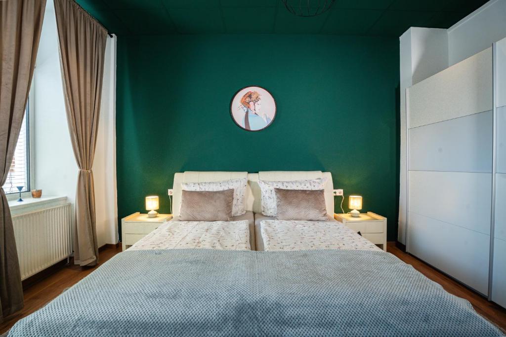 a bedroom with a bed with a green wall at Alpenloft Bregenz in Bregenz
