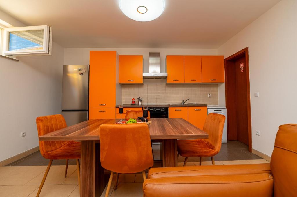 a kitchen with a wooden table and orange cabinets at Casa delle Rondini in Belej