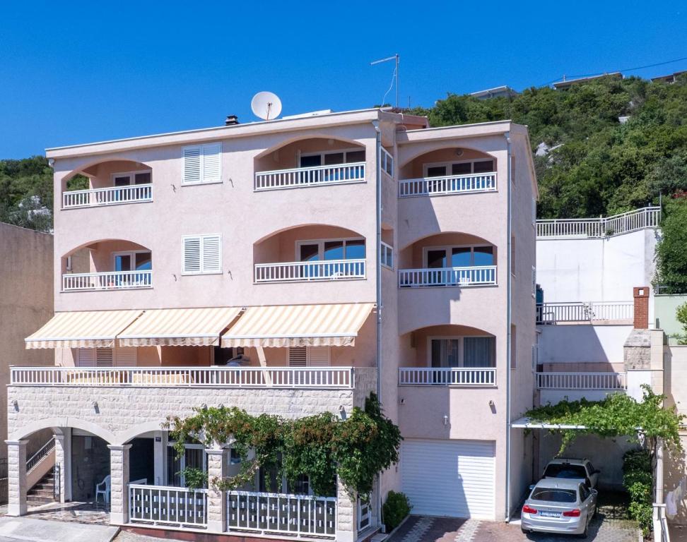 a building with a car parked in front of it at Apartments Obradović in Neum