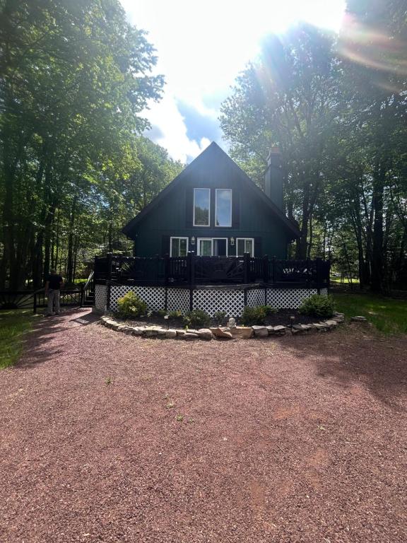 a black house with a fence in front of it at The Emerald Cabin in Tobyhanna