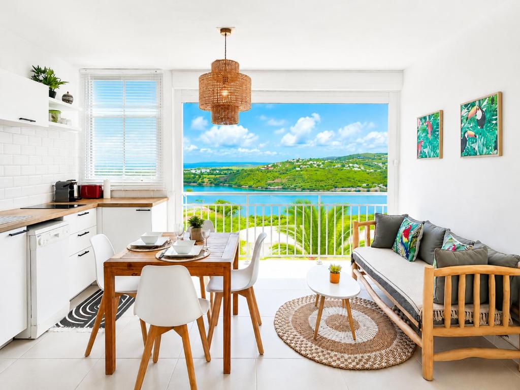a kitchen and living room with a view of the ocean at Studio ALIZEA in Saint Martin