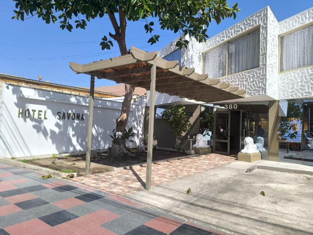 a building with an umbrella in front of it at Hotel Savona in Arica