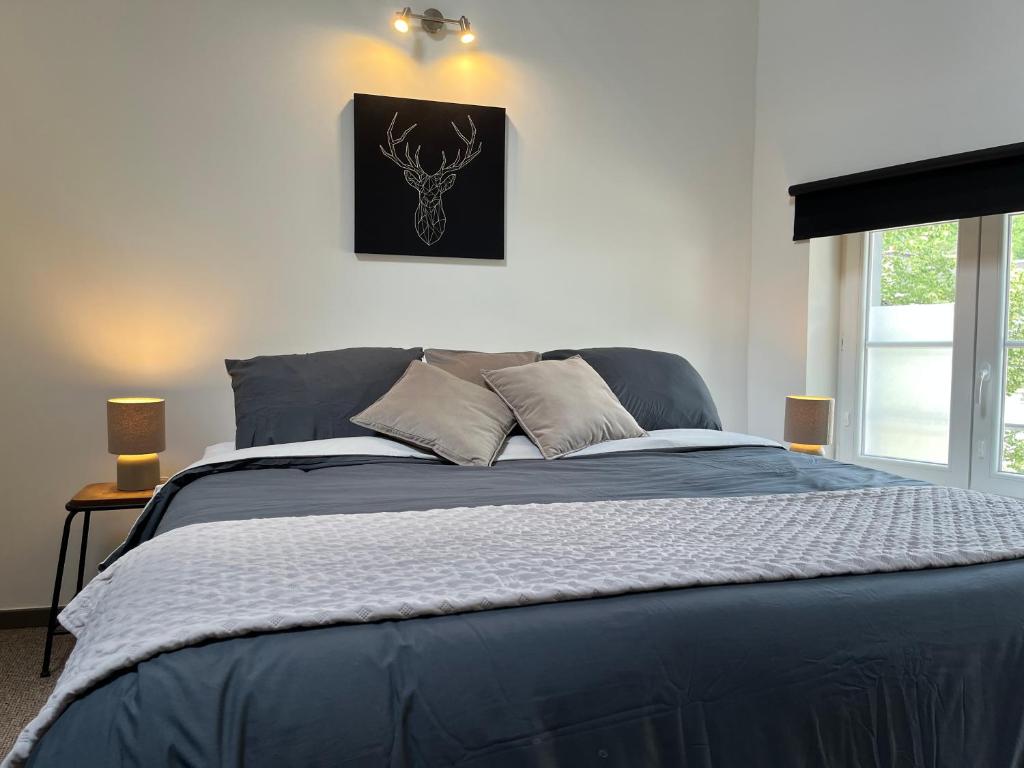 a bedroom with a blue bed with a picture on the wall at Week end à Spa in Spa