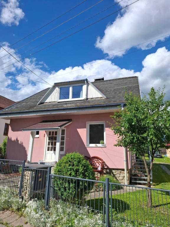 a pink house with a fence at Chalupa u Strakov in Lúčky