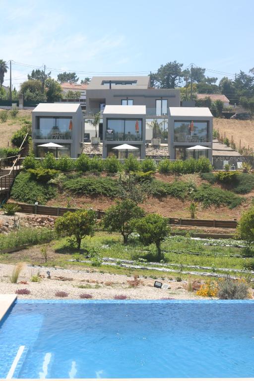 a house on a hill with a swimming pool at Zambujal Suites in Sesimbra