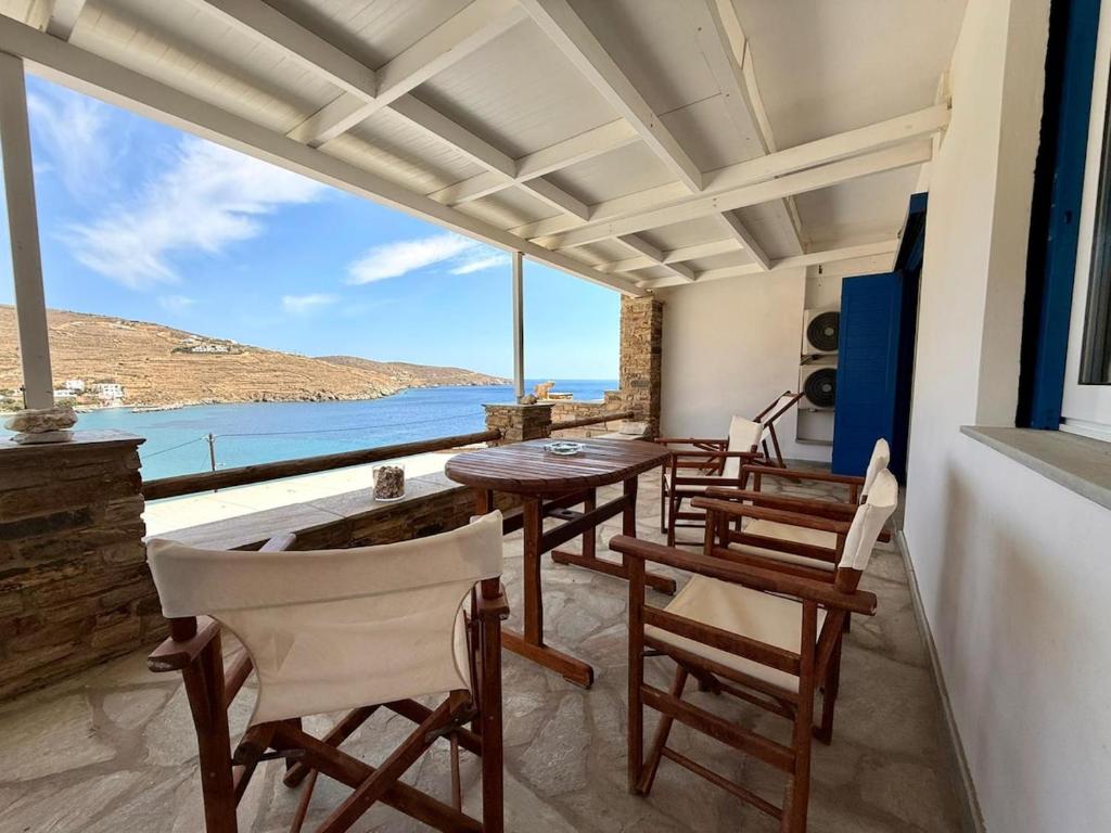 a dining room with tables and chairs and a view of the ocean at Aegean Big Blue -Rosalie Home in Tinos