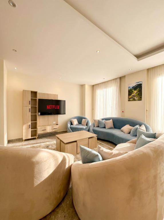 a living room with two couches and a tv at Elite hotel in Sheikh Zayed