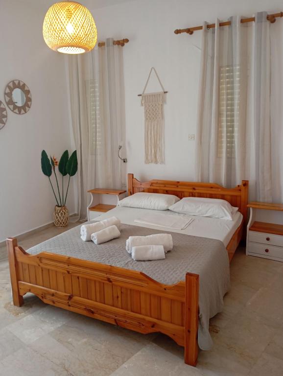 a bedroom with a large wooden bed with towels on it at Spacious Apartment Garden View Partial Seaview in Makry Gialos