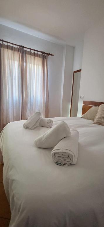 a bedroom with two white towels on a bed at Casa Curro in Benaocaz