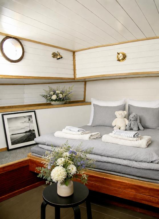a bed on a boat with flowers on a table at Saimaa Experience in Savonlinna