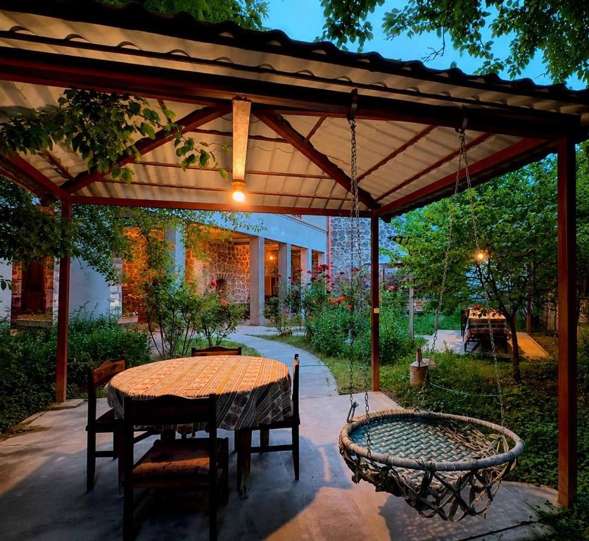 eine Terrasse mit Tisch und Stühlen unter einer Pergola in der Unterkunft Christy Hotel in Goris