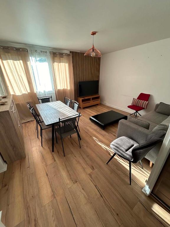 a living room with a table and a couch at Happy Beautiful Home in Cholet