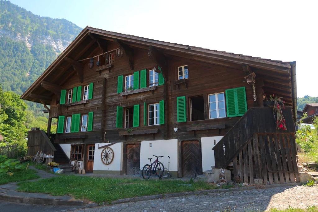 a wooden house with green shuttered windows and a bike at Lakeview Chalet 1 , Drligen in Därligen