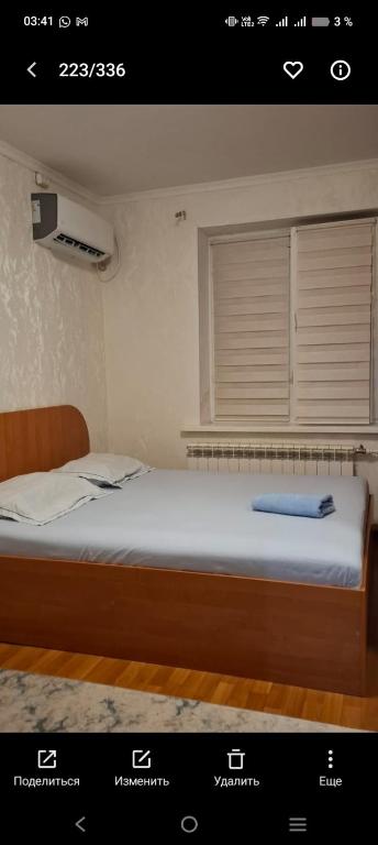 a bed in a room with a window and a bed sidx sidx sidx at Уютный уголок in Aktobe