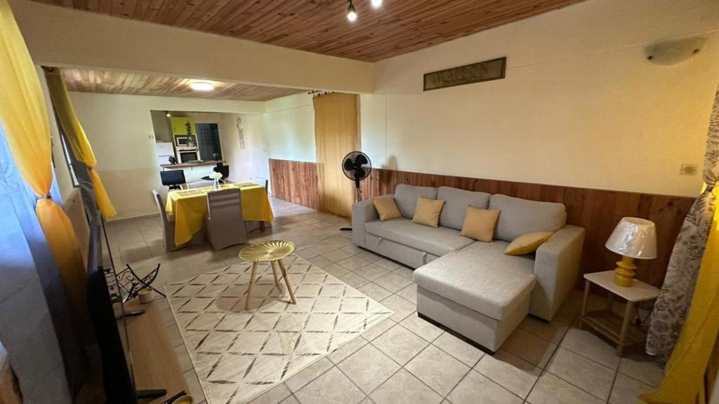 a living room with a couch and a table at La Maison Du Bonheur in Capesterre-Belle-Eau