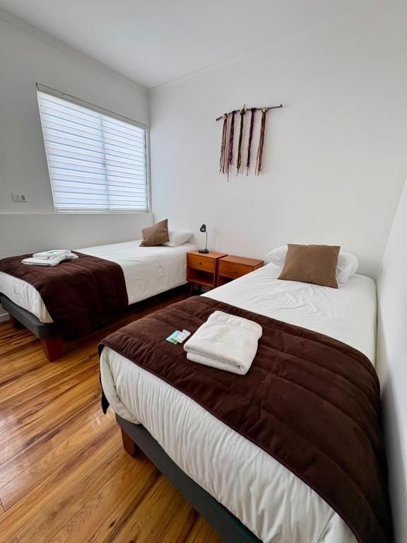 a bedroom with two beds and a window at Hotel San Francisco De la Selva in Copiapó
