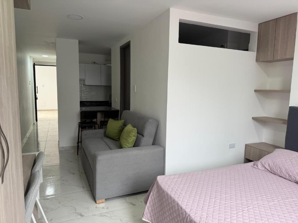 a bedroom with a couch and a bed in a room at Hermosos Apartaestudios! in Florencia