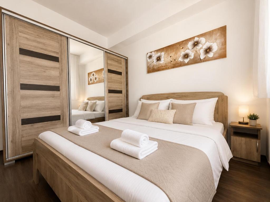 a bedroom with a large bed with towels on it at LOTZ Apartman in Pécs