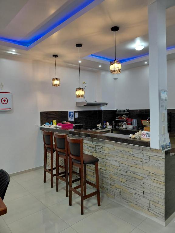 a kitchen with a bar with chairs and lights at Casa Puka in Puerto Baquerizo Moreno