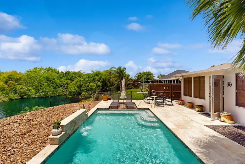a swimming pool with a fountain in front of a house at Golden Palms in Laguna Vista
