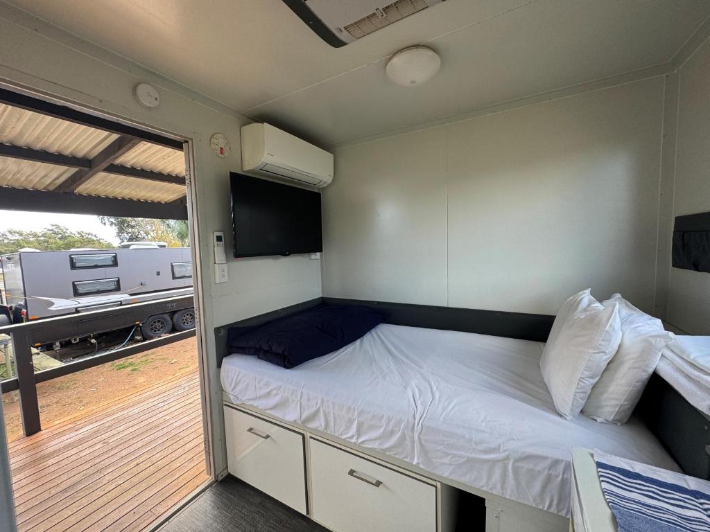 a small bedroom with a bed and a balcony at Camden Holiday Park in Camden