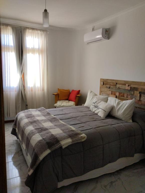 a bedroom with a bed with a blanket and a window at Annie in La Falda