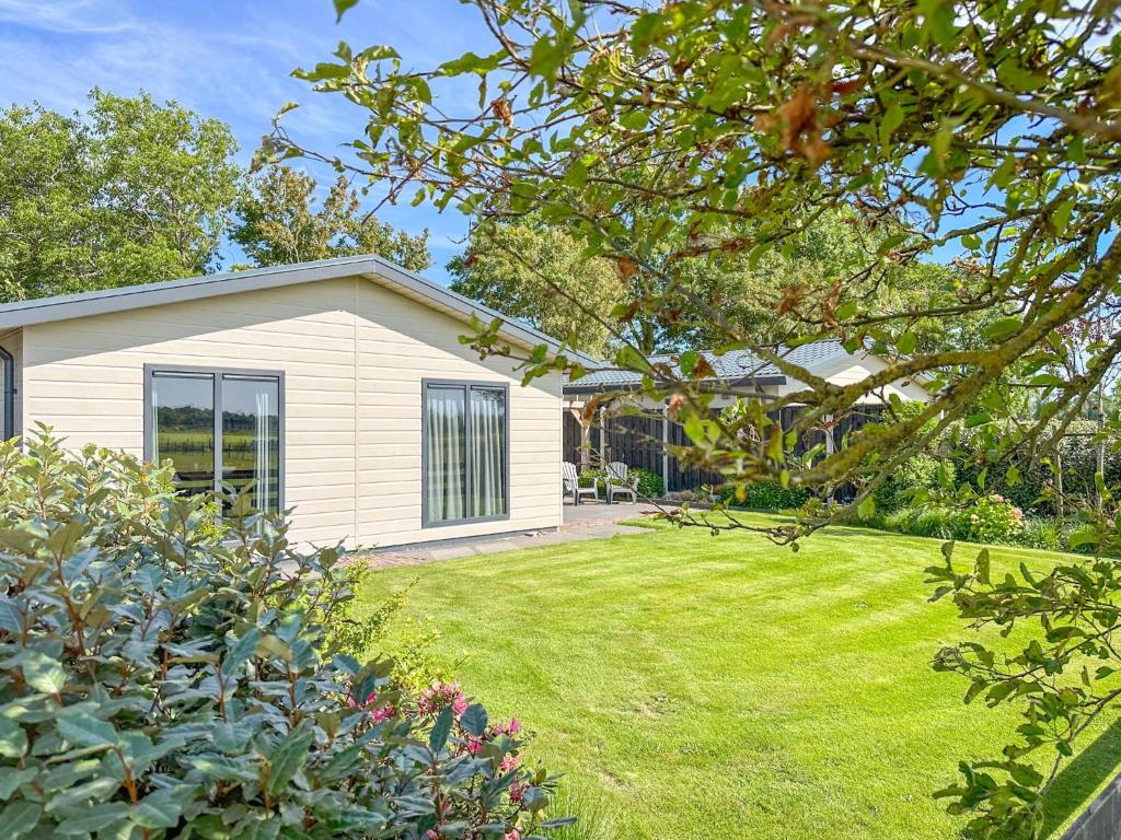 a white house with a yard with a grassy lawn at De Zwaluw in Heiloo