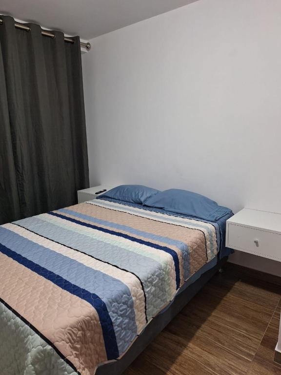 a bedroom with a bed with a blue and white blanket at Dormitorio matrimonial 01 in Lima