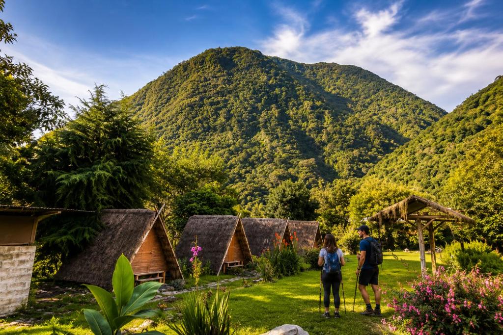 a group of people standing in front of a mountain at EcoSereno Salkantay Huts Chaullay in Santa Teresa