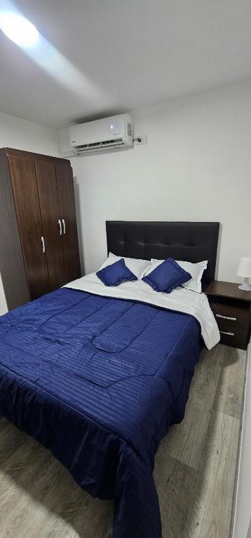 a bedroom with a blue and white bed with blue pillows at Balcones de las lajas in Cali