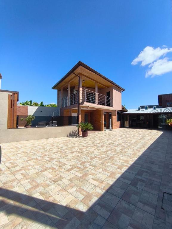 ein Haus mit einer großen, mit Ziegeln gepflasterten Auffahrt davor in der Unterkunft Mar e lar e lazer in Pinheira