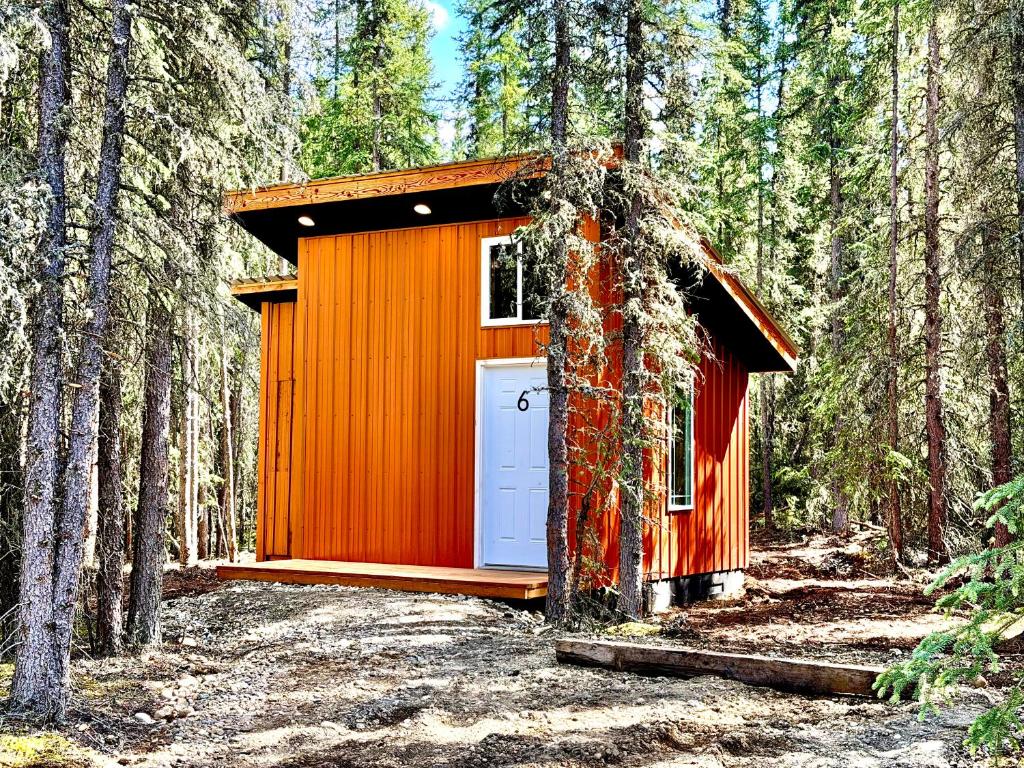 an orange building in the middle of a forest at Roberts Lodge in Tok