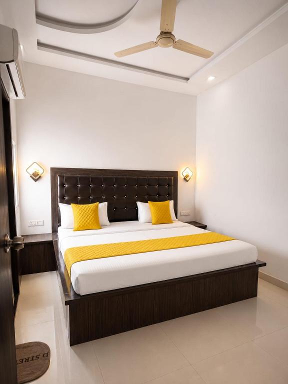 a bedroom with a large bed with yellow pillows at La Buddha Villagers BY Ansh Palace Hotel in Agra