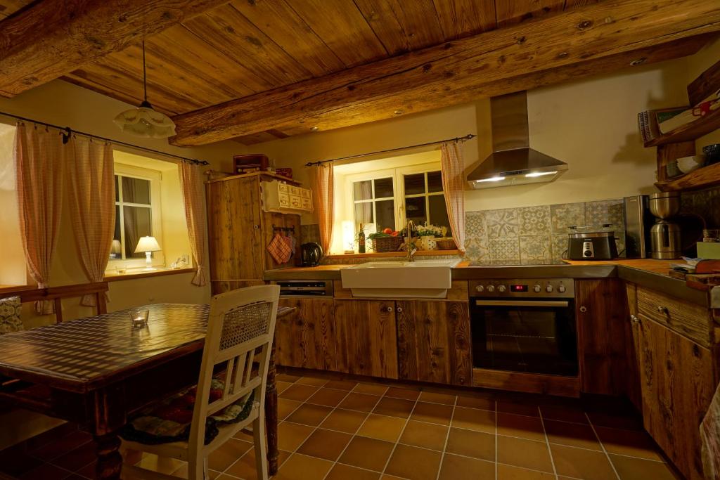 een keuken met een tafel en een fornuis top oven bij Goldbachhäuschen in Olbersdorf