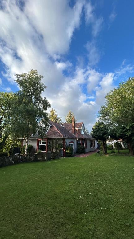 a house in a yard with a grass field at The Cairn in Airdrie