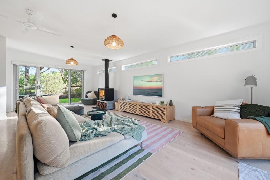 a living room with two couches and a tv at Tamara Coastal Retreat in Inverloch