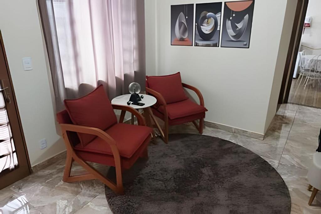 a living room with two chairs and a table at Tecnohouse próxima ao Sesc in Franca