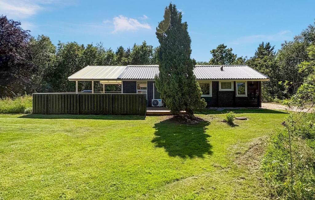 a small house with a tree in a yard at Cozy Home In Jerup With Wifi in Jerup